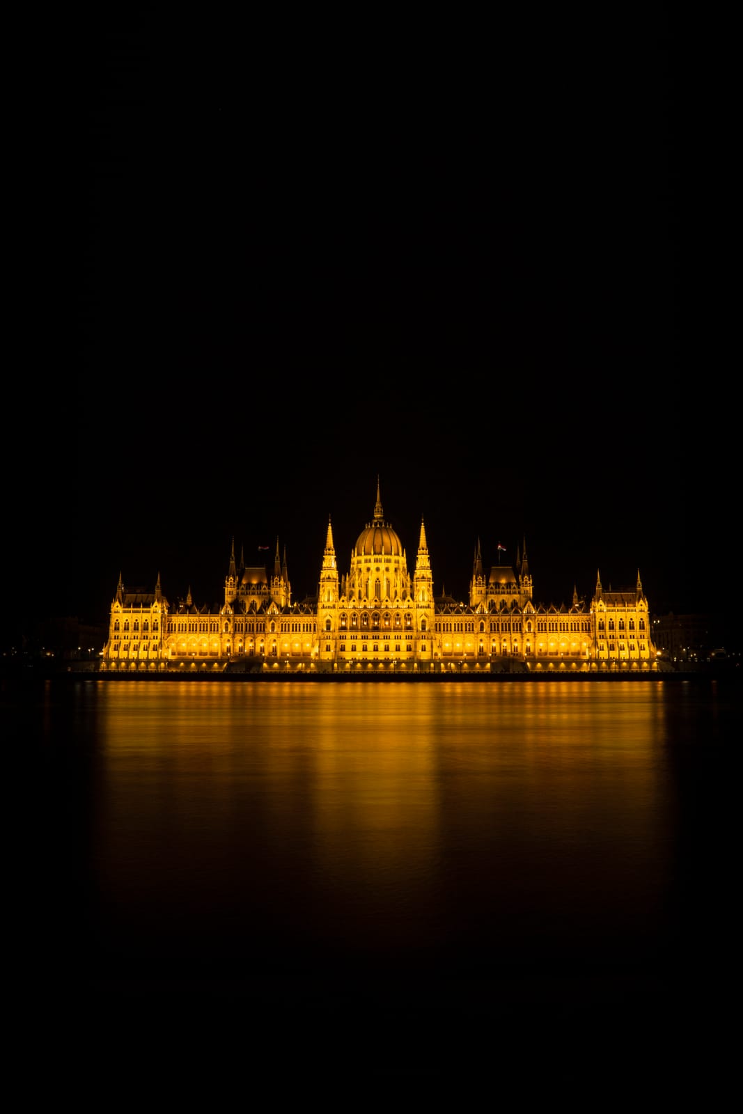 Hungarian Parliament lit gold at night, reflected in the Danube, Budapest.