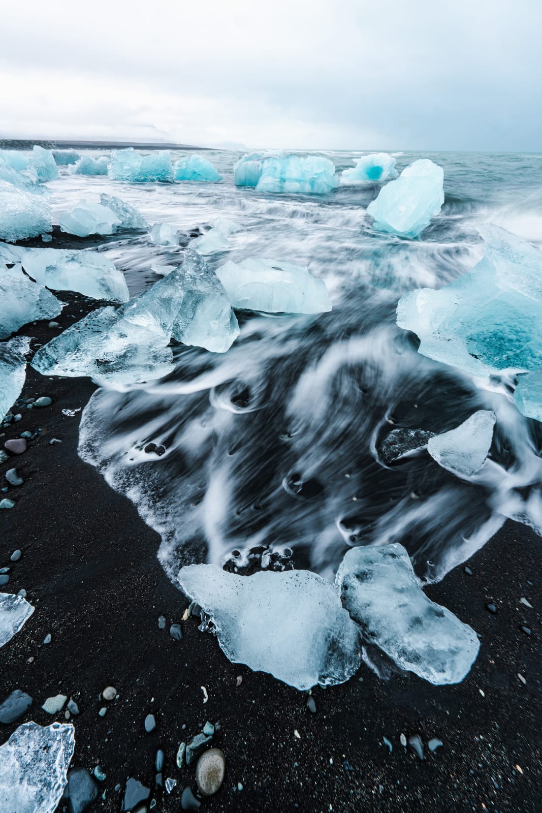 Ice blocks on a black-sand beach.